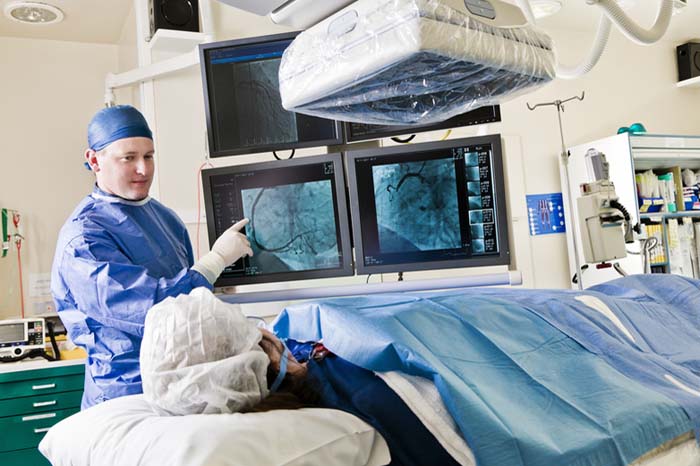 Cath lab procedure with Interventionalist discussing the procedure with patient